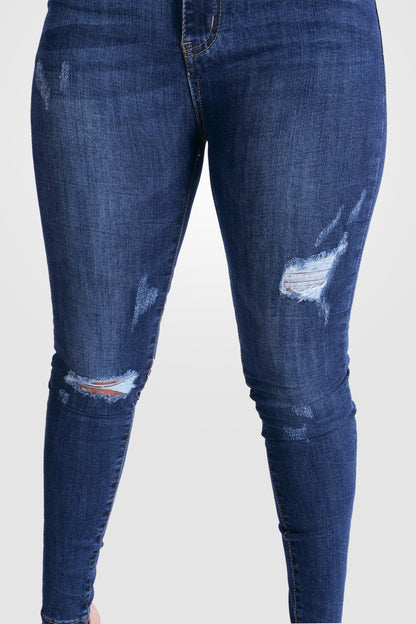 BLAUE STRETCH-JEANS MIT KRATZERN MIT MITTLERER TAILLE